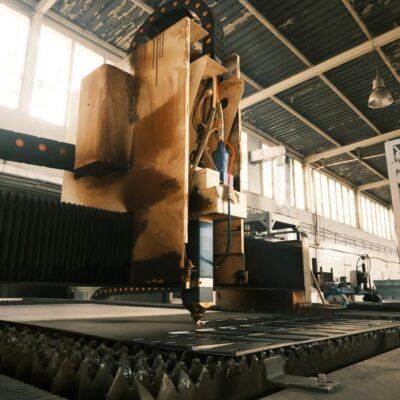 Laser cutting machine working in a sunlit factory environment.